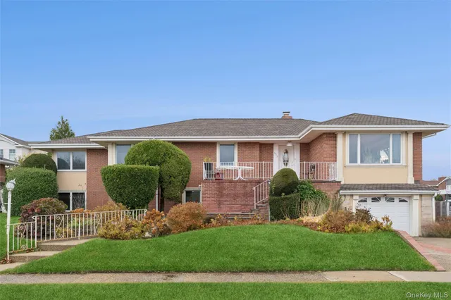 a front view of a house with a yard and potted plants