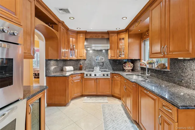 a kitchen with stainless steel appliances granite countertop a sink a stove and cabinets