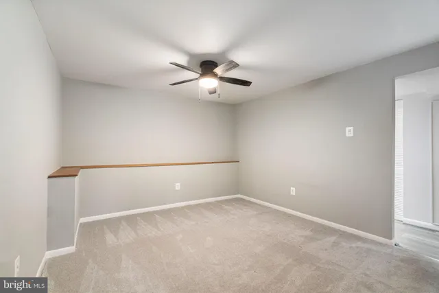 a view of an empty room with a fireplace and a window
