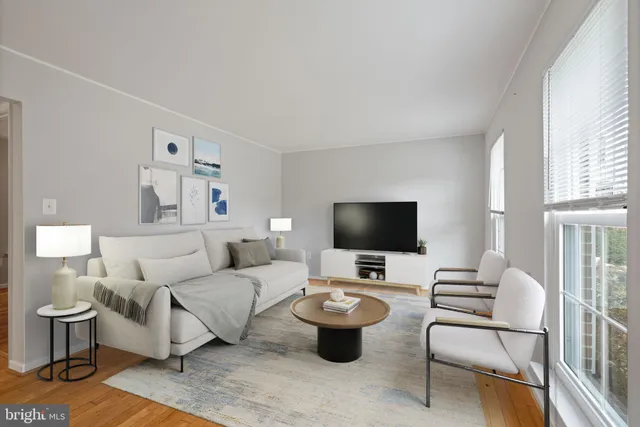 a living room with furniture a flat screen tv and a window