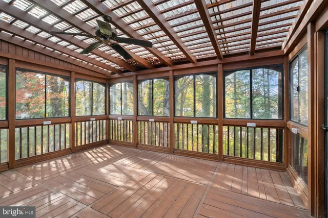 a view of a hallway with wooden floor and a bathroom
