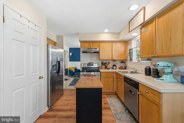 a kitchen with stainless steel appliances granite countertop refrigerator stove top oven and sink