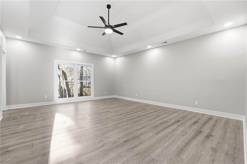 2152 Paces Vale Place Lawrenceville, GA 30043 - Photo 17 of 39 an empty room with wooden floor fan and windows