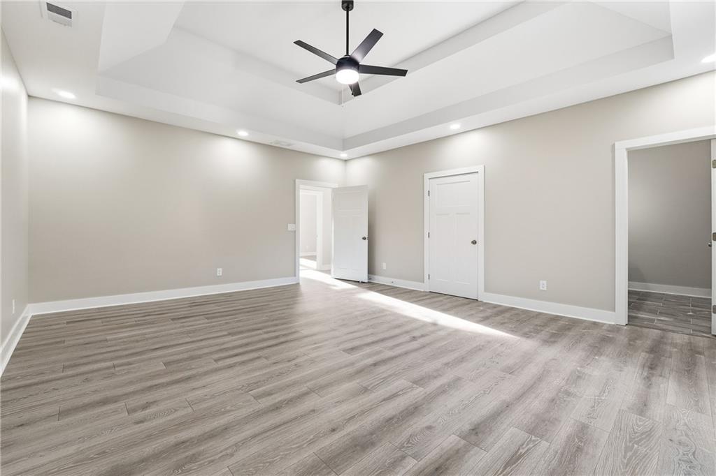 2152 Paces Vale Place Lawrenceville, GA 30043 - Photo 18 of 39 an empty room with wooden floor and ceiling fan