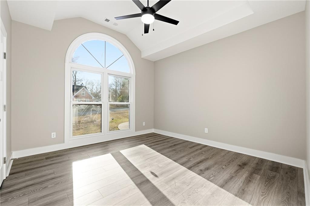 2152 Paces Vale Place Lawrenceville, GA 30043 - Photo 21 of 39 an empty room with wooden floor chandelier and windows