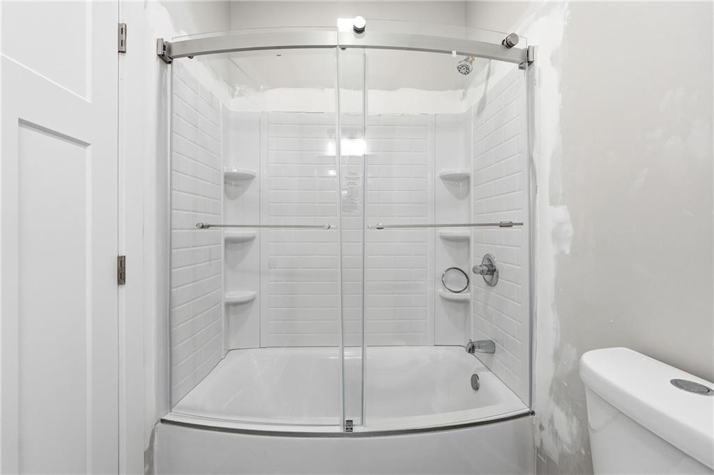 2152 Paces Vale Place Lawrenceville, GA 30043 - Photo 23 of 39 a bathroom with a white bath tub and a shower