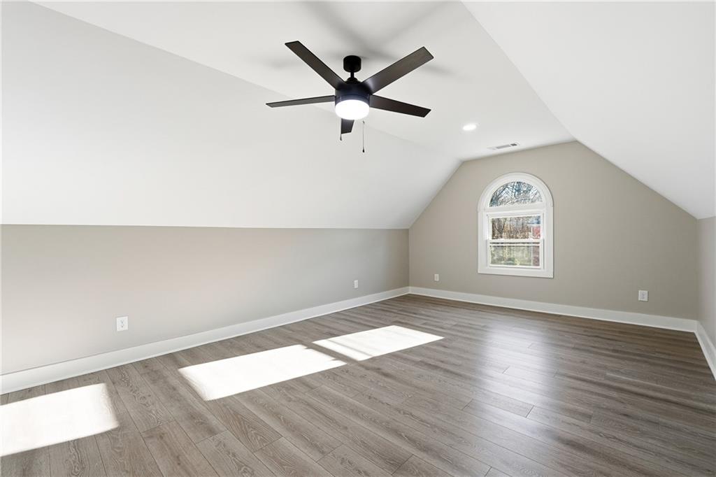 2152 Paces Vale Place Lawrenceville, GA 30043 - Photo 24 of 39 an empty room with wooden floor a ceiling fan and windows