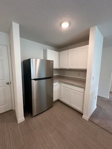 a kitchen with a refrigerator and a stove top oven