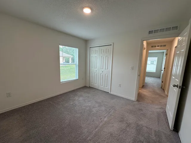 an empty room with windows and closet