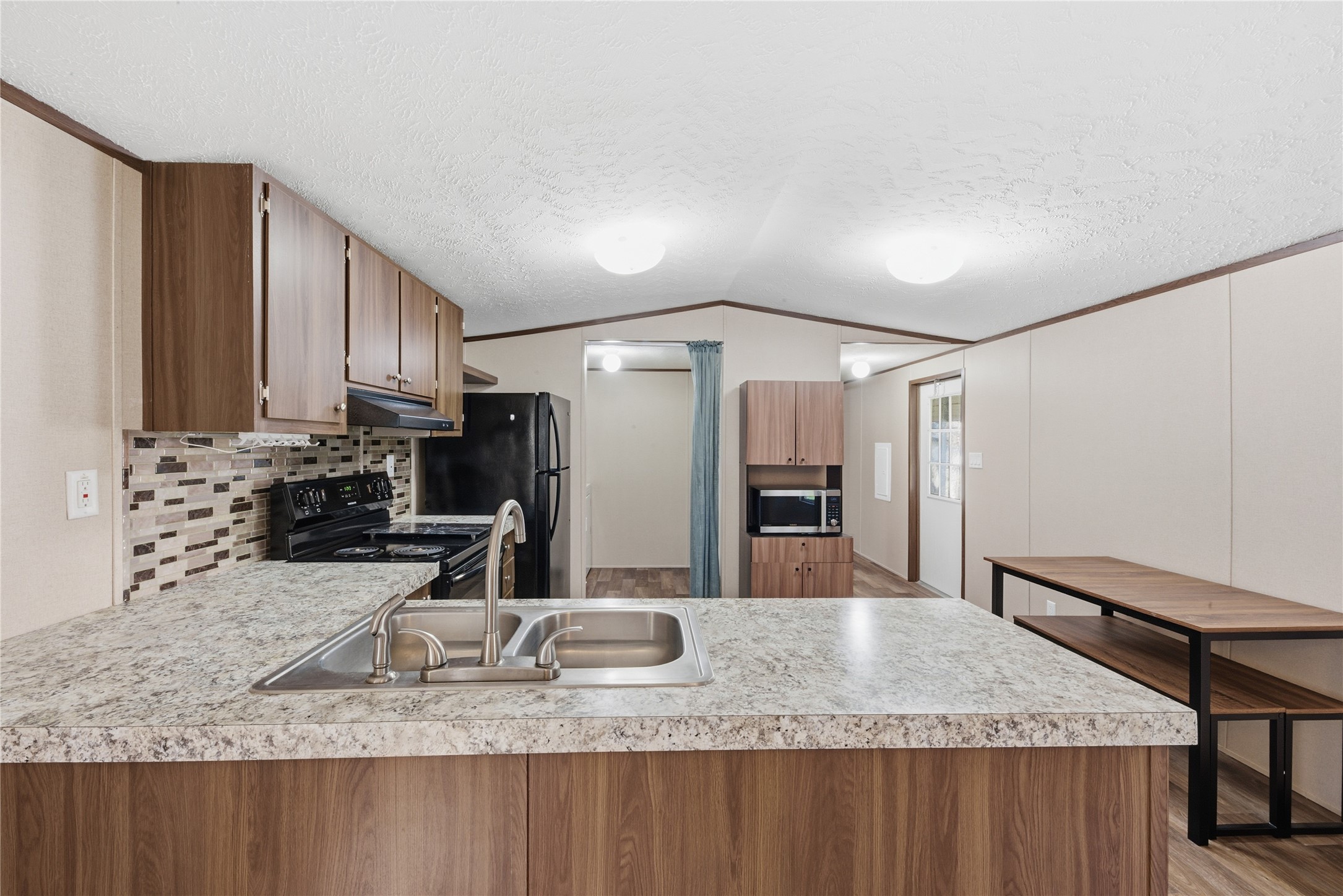 100 St Croix Drive Point Blank, TX 77364 - Photo 3 of 28 a kitchen with kitchen island granite countertop a sink and refrigerator