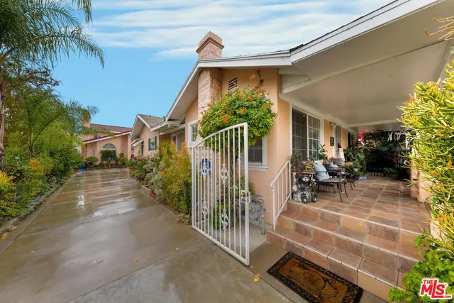 a view of house and patio with swimming pool and sitting area
