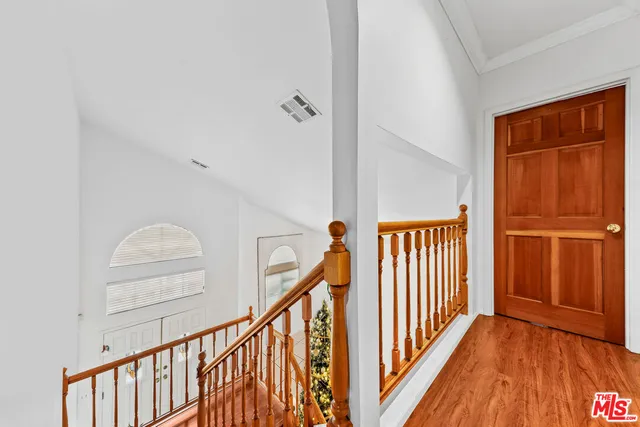 a view of a hallway with wooden floor and staircase