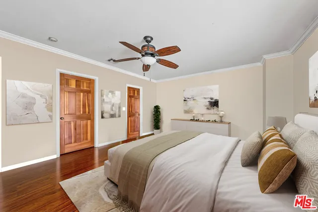 a bedroom with a large bed and a chandelier
