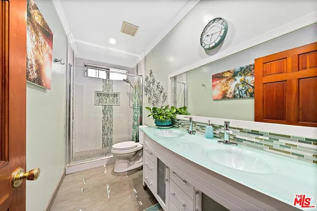 a spacious bathroom with a granite countertop sink a toilet and a shower