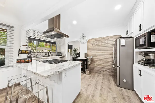 a kitchen with stainless steel appliances kitchen island granite countertop a refrigerator and a stove