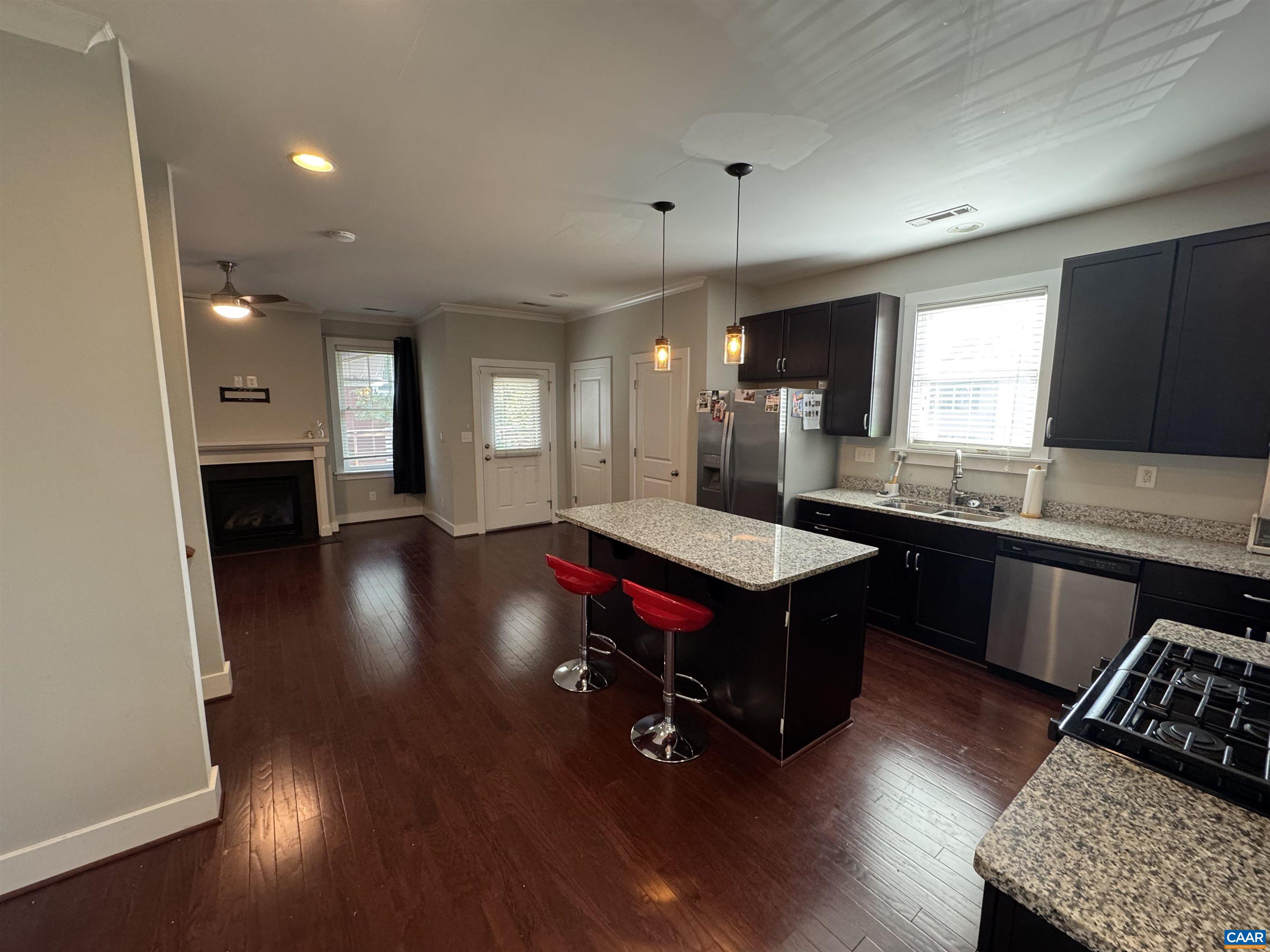 516 Rives Street Charlottesville, VA 22902 - Photo 8 of 26 a kitchen with stainless steel appliances granite countertop a refrigerator a sink dishwasher a stove and a dining table with wooden floor
