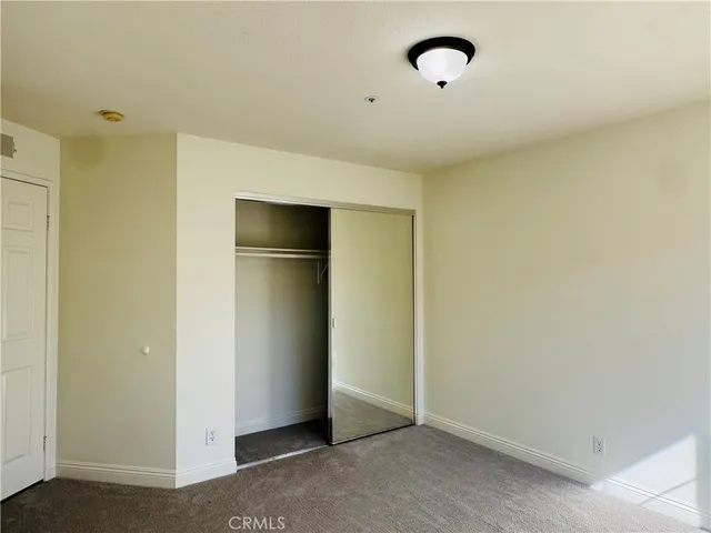 an empty room with windows and closet