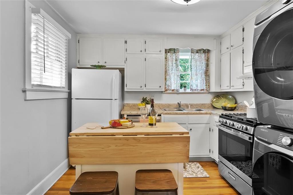 2218 East Street Covington, GA 30014 - Photo 17 of 38 a kitchen with stainless steel appliances granite countertop a sink stove and refrigerator