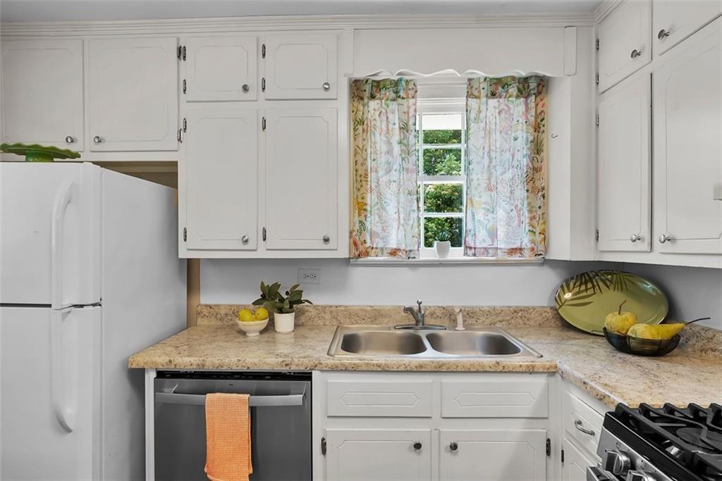 2218 East Street Covington, GA 30014 - Photo 19 of 38 a kitchen with stainless steel appliances granite countertop a sink a stove and cabinets