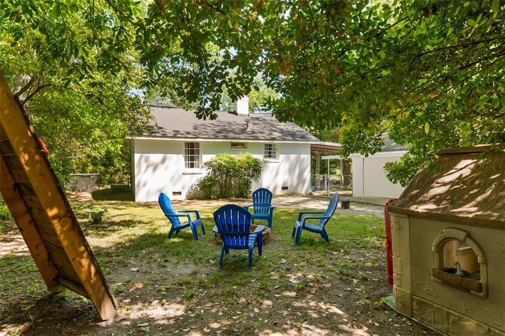 2218 East Street Covington, GA 30014 - Photo 33 of 38 a view of a patio with table and chairs potted plants and a large tree