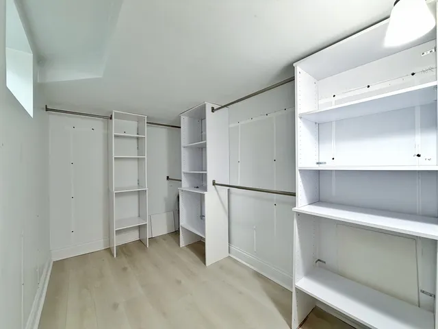 a view of a kitchen with refrigerator and white cabinets