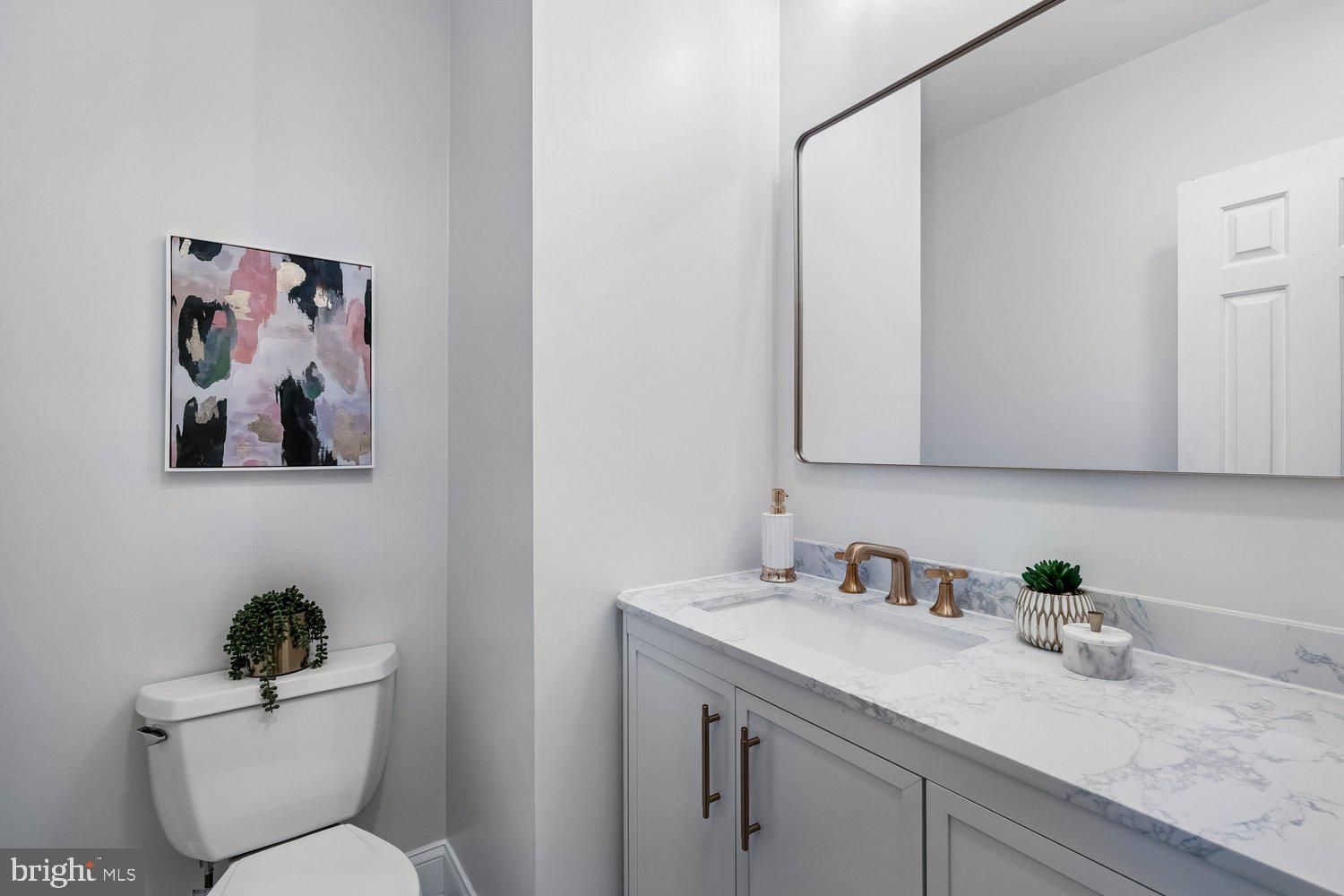 1652 Kramer Street Northeast Washington, DC 20002 - Photo 13 of 26 a bathroom with a granite countertop toilet sink and mirror