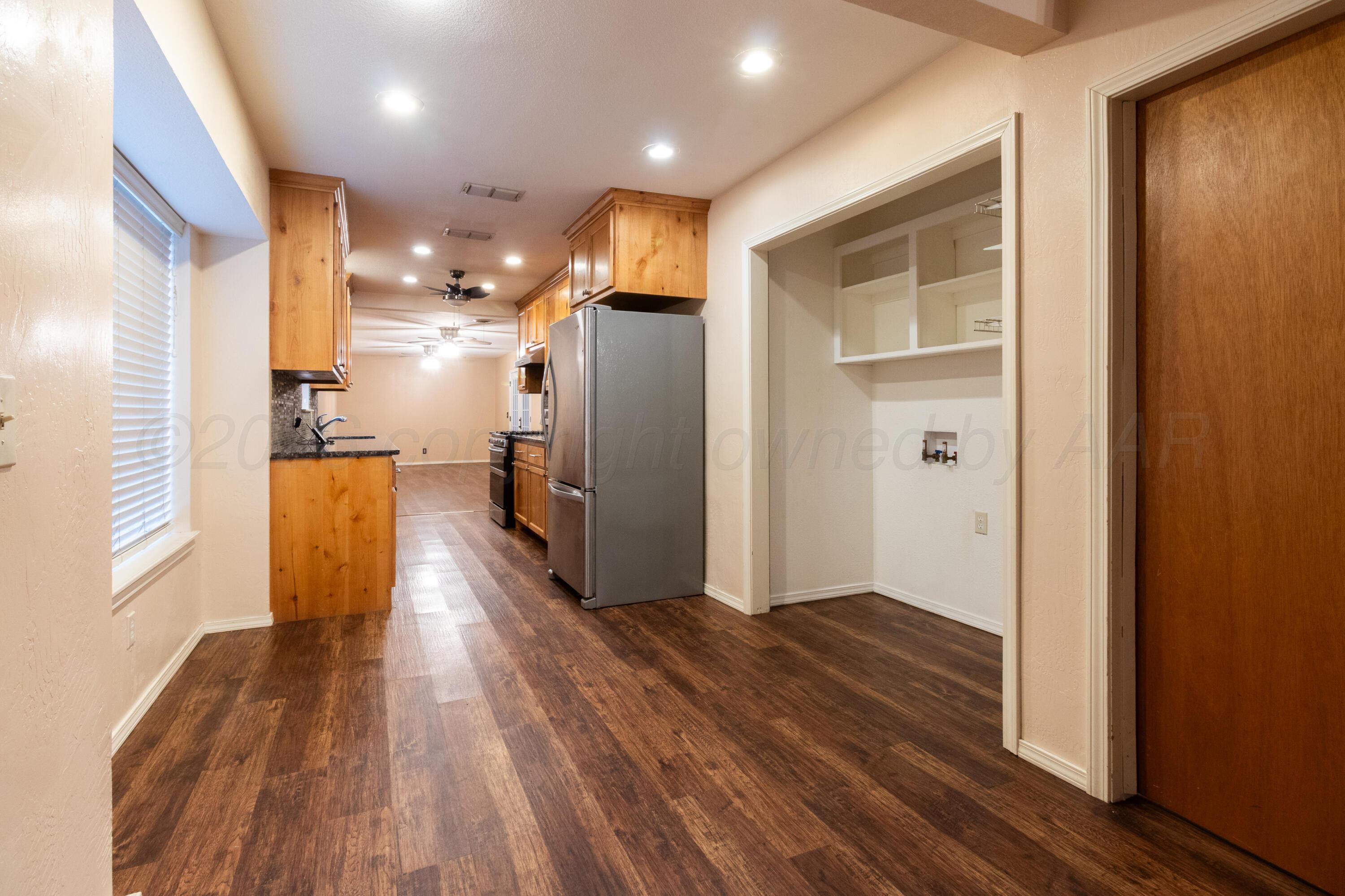 3211 Hodges Street Amarillo, TX 79103 - Photo 11 of 32 a view of a refrigerator in kitchen and wooden floor