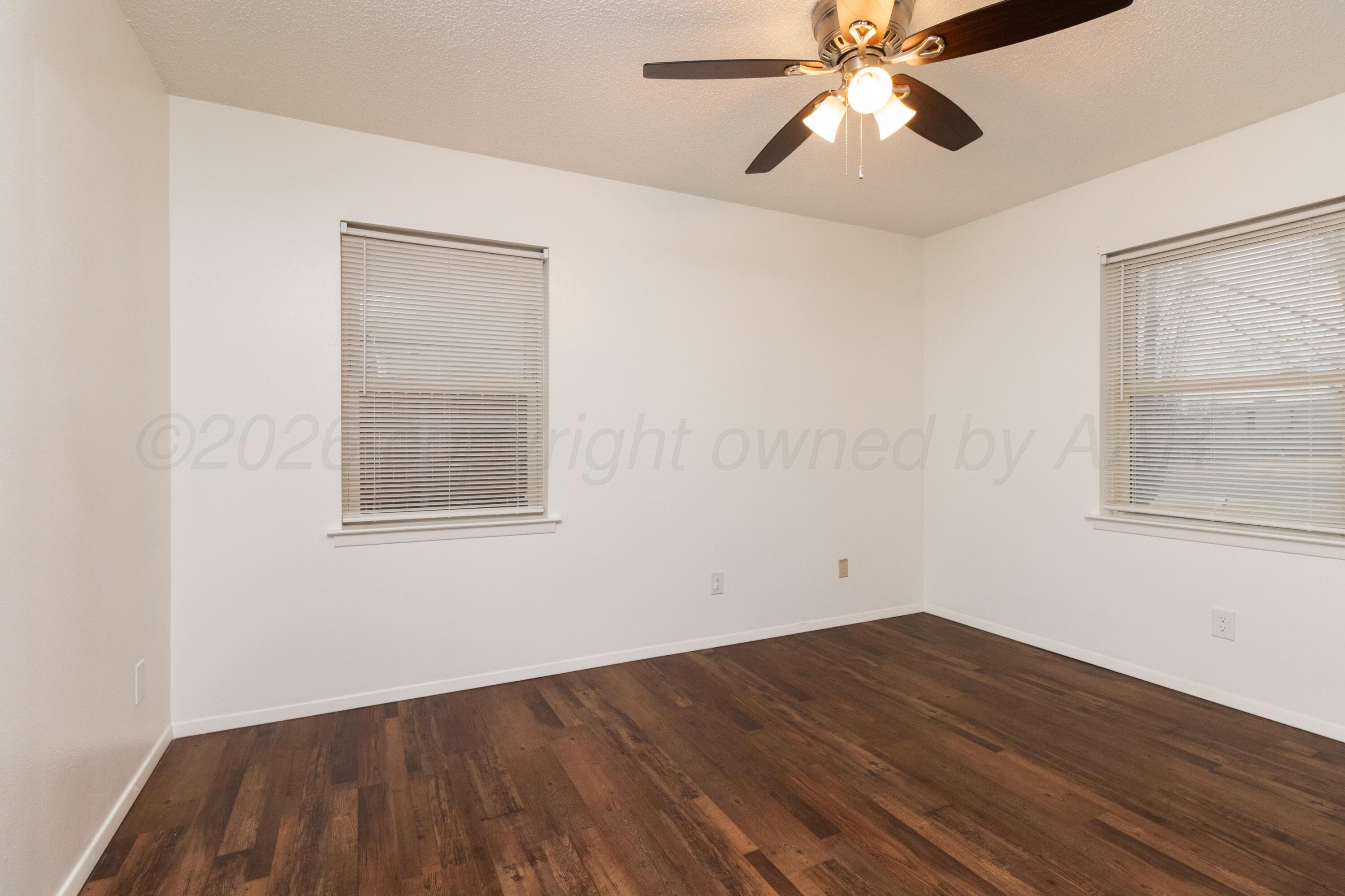 3211 Hodges Street Amarillo, TX 79103 - Photo 17 of 32 a view of an empty room with wooden floor and a window
