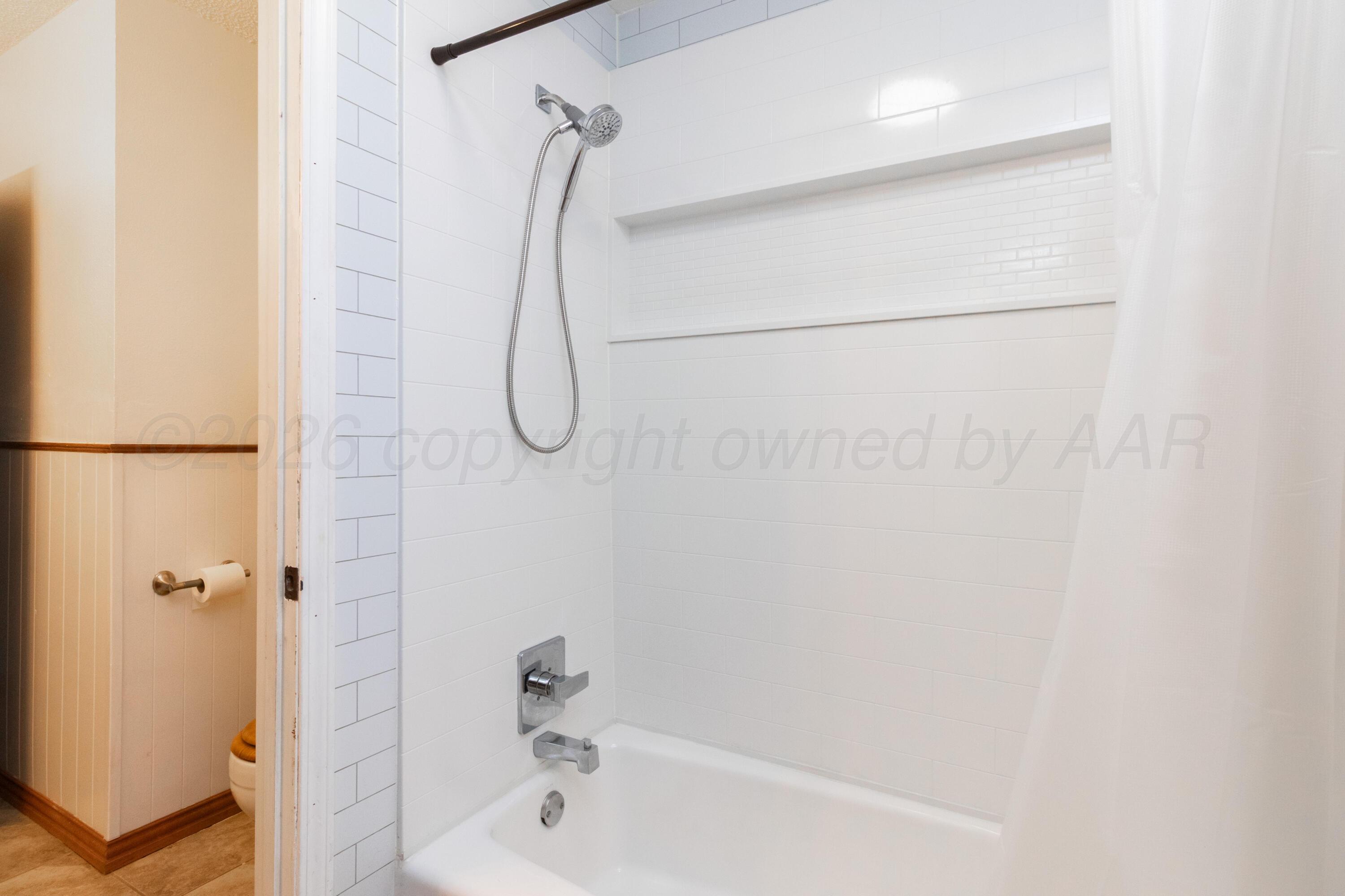 3211 Hodges Street Amarillo, TX 79103 - Photo 20 of 32 a bathroom with a bath tub with a shower