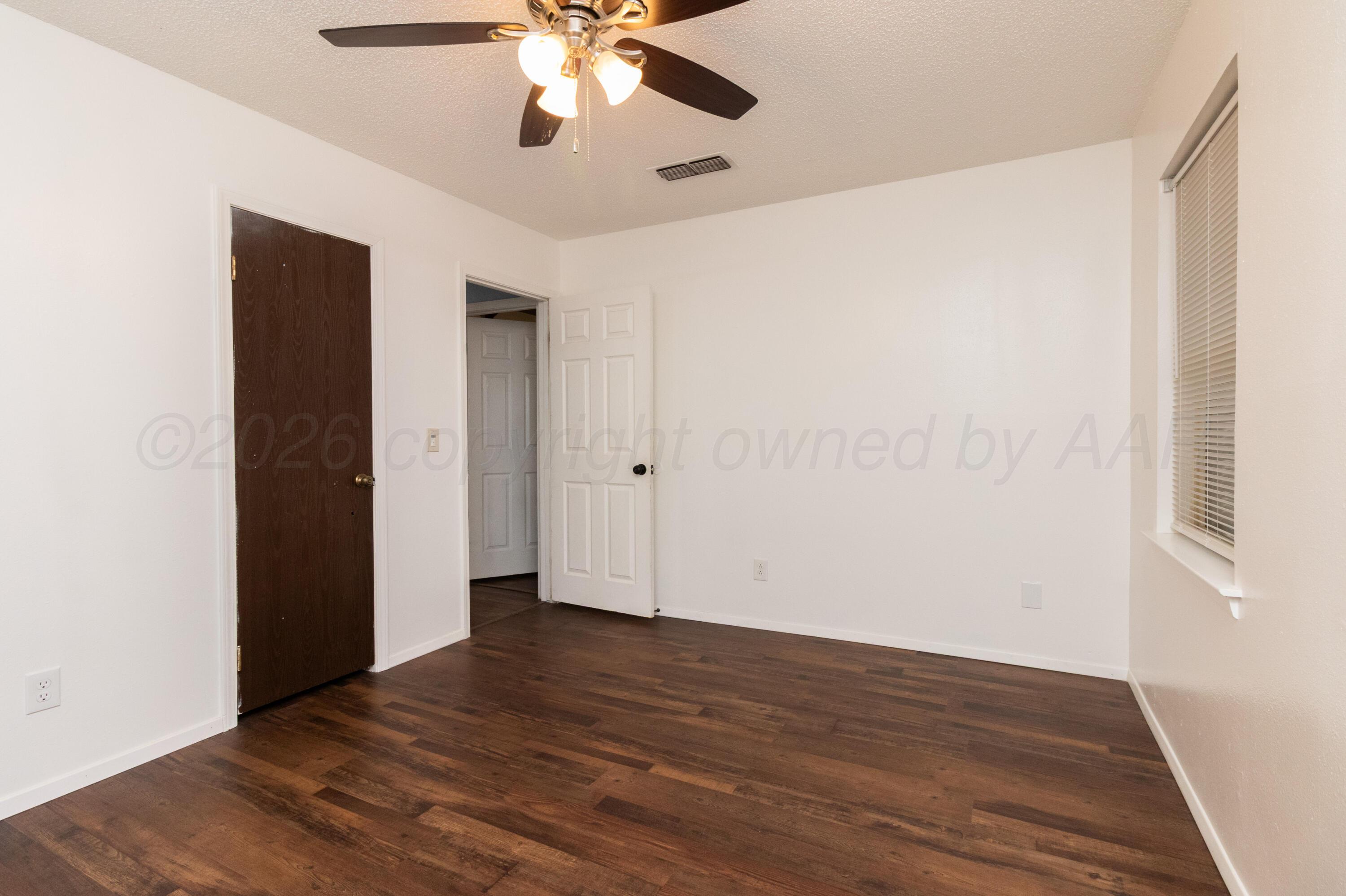 3211 Hodges Street Amarillo, TX 79103 - Photo 22 of 32 a view of an empty room with wooden floor and a ceiling fan
