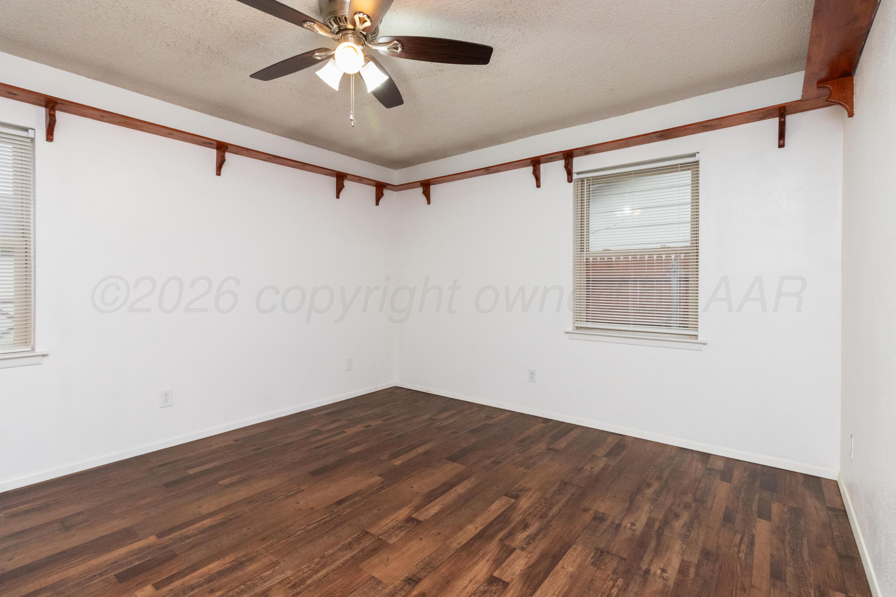 3211 Hodges Street Amarillo, TX 79103 - Photo 23 of 32 a view of a big room with wooden floor and a ceiling fan