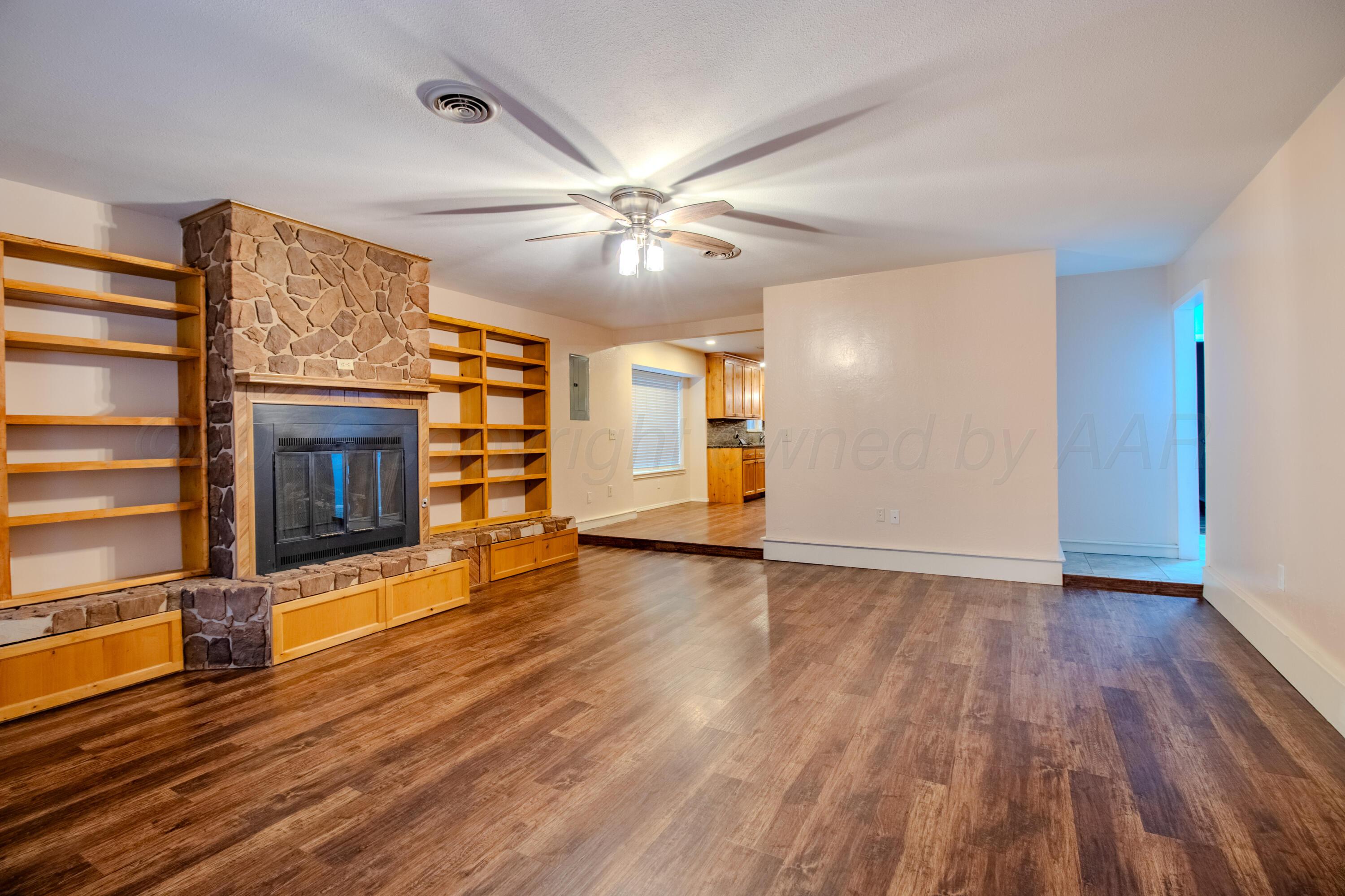 3211 Hodges Street Amarillo, TX 79103 - Photo 6 of 32 a view of an empty room with wooden floor fireplace and a window