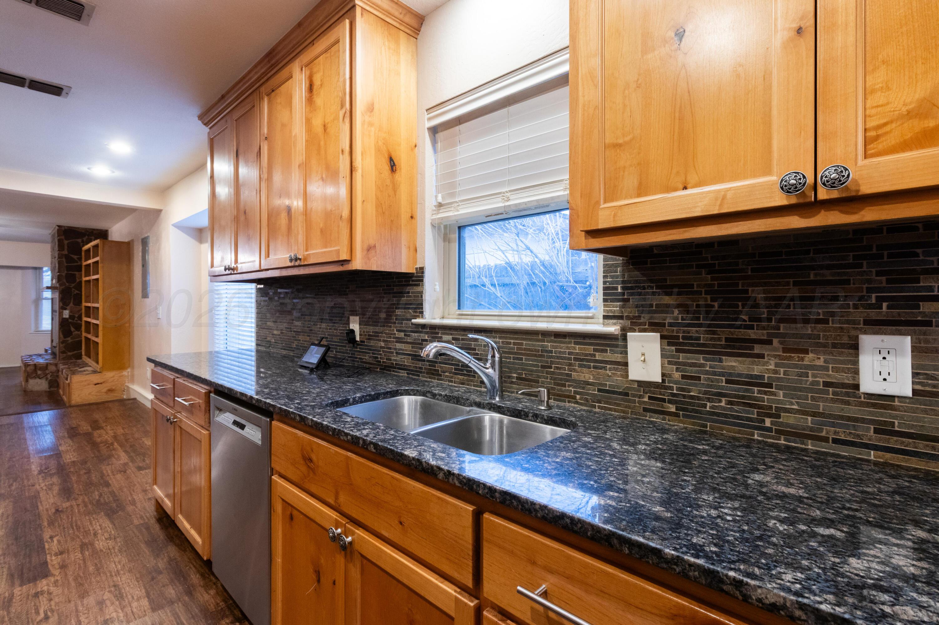 3211 Hodges Street Amarillo, TX 79103 - Photo 10 of 32 a kitchen with granite countertop sink and cabinets