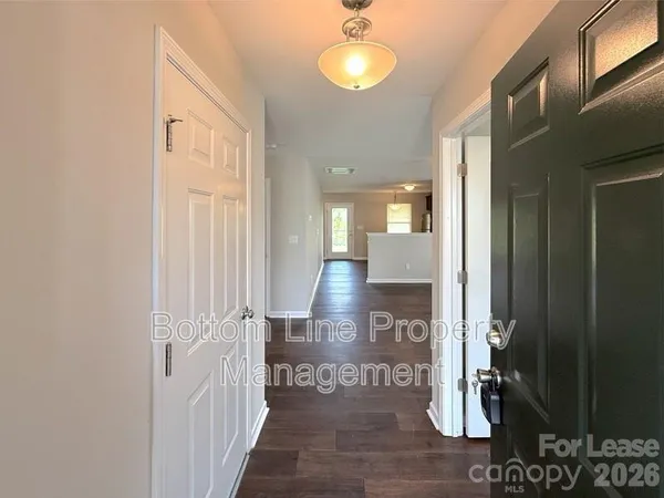 a view of a hallway with wooden floor and dining room