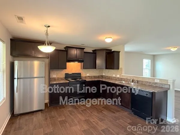 a kitchen with stainless steel appliances granite countertop a stove a refrigerator and a microwave