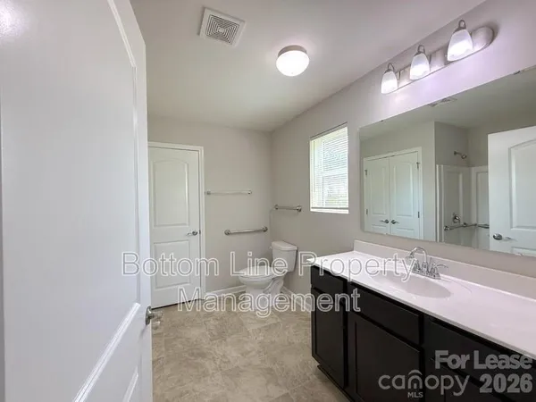 a bathroom with a sink a toilet and a mirror