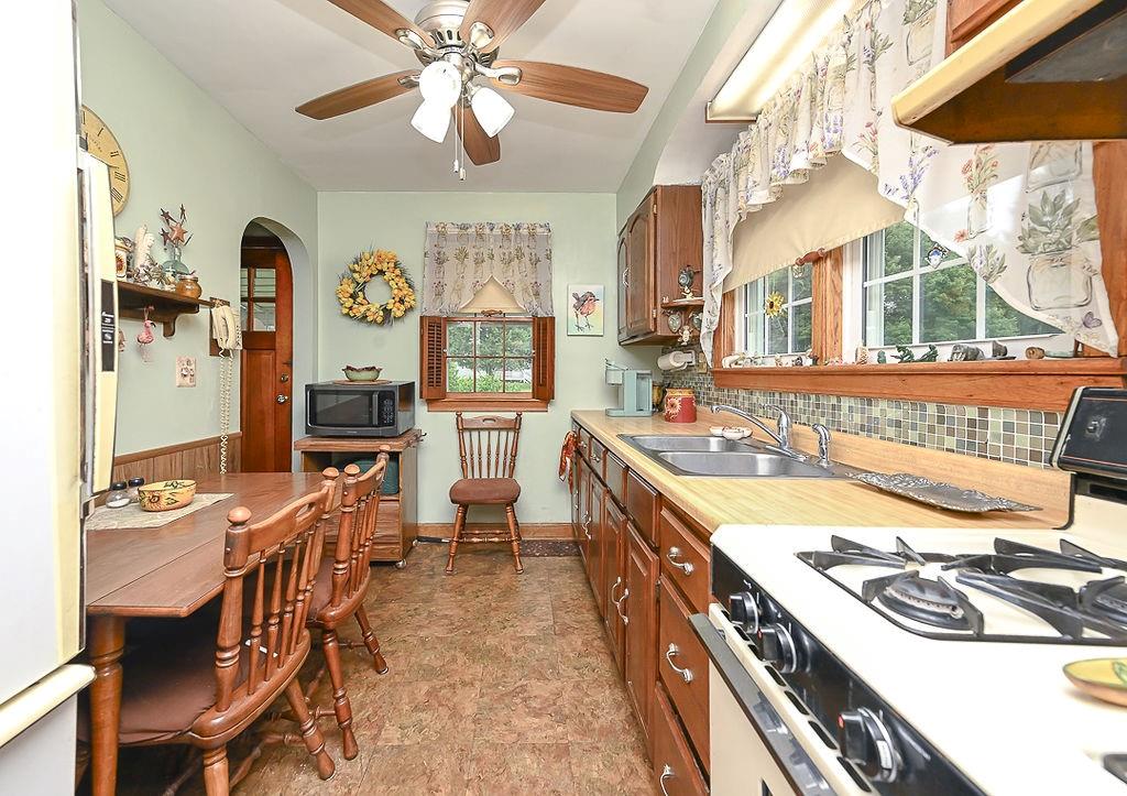 4515 Tuscarawas Road Beaver, PA 15009 - Photo 26 of 50 a kitchen with stainless steel appliances a stove a sink dishwasher and a dining table with wooden floor
