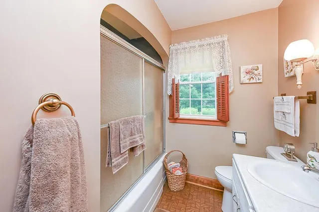 a bathroom with a sink a toilet and a mirror