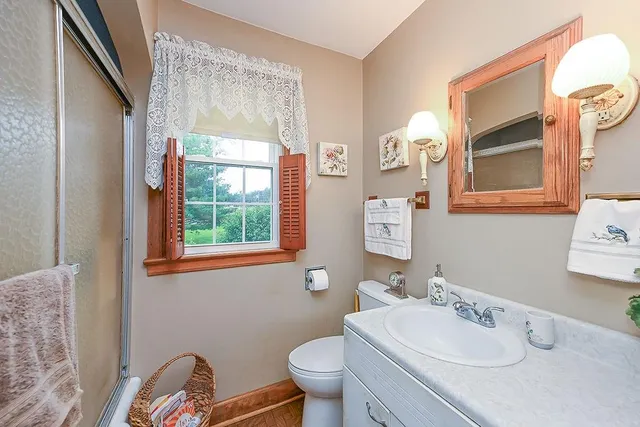 a bathroom with a sink a toilet and a mirror