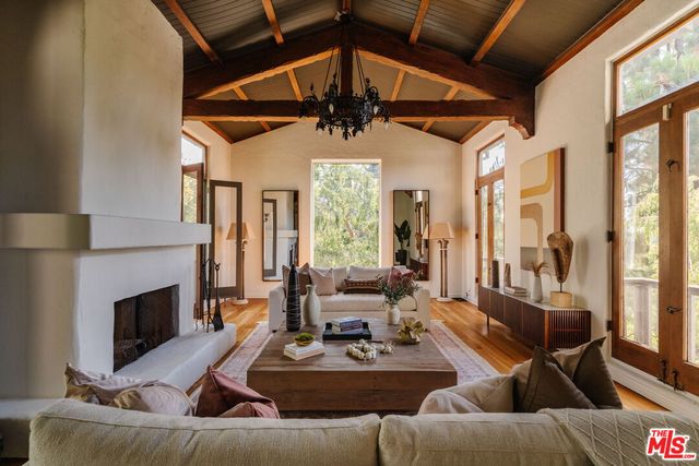 a living room with furniture a fireplace and a large window