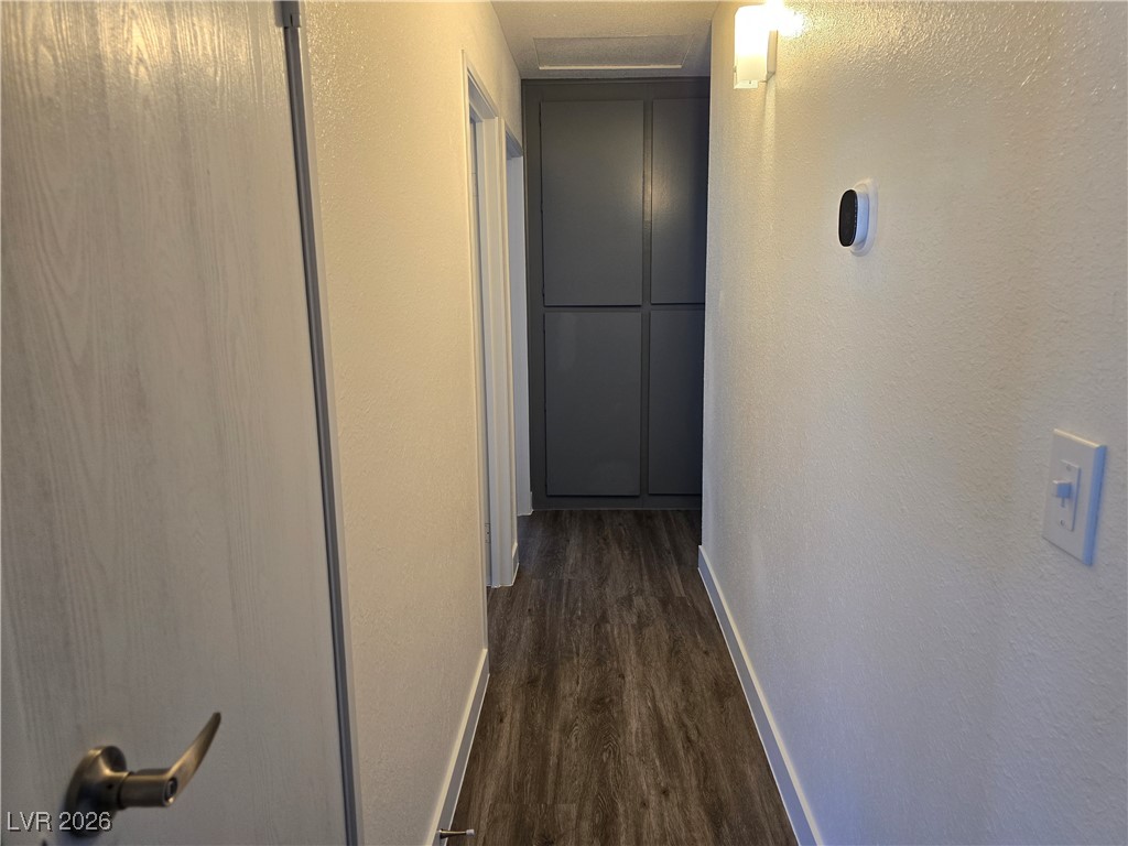4219 Studio Street Las Vegas, NV 89115 - Photo 11 of 33 Hall with a textured wall and dark wood-style flooring