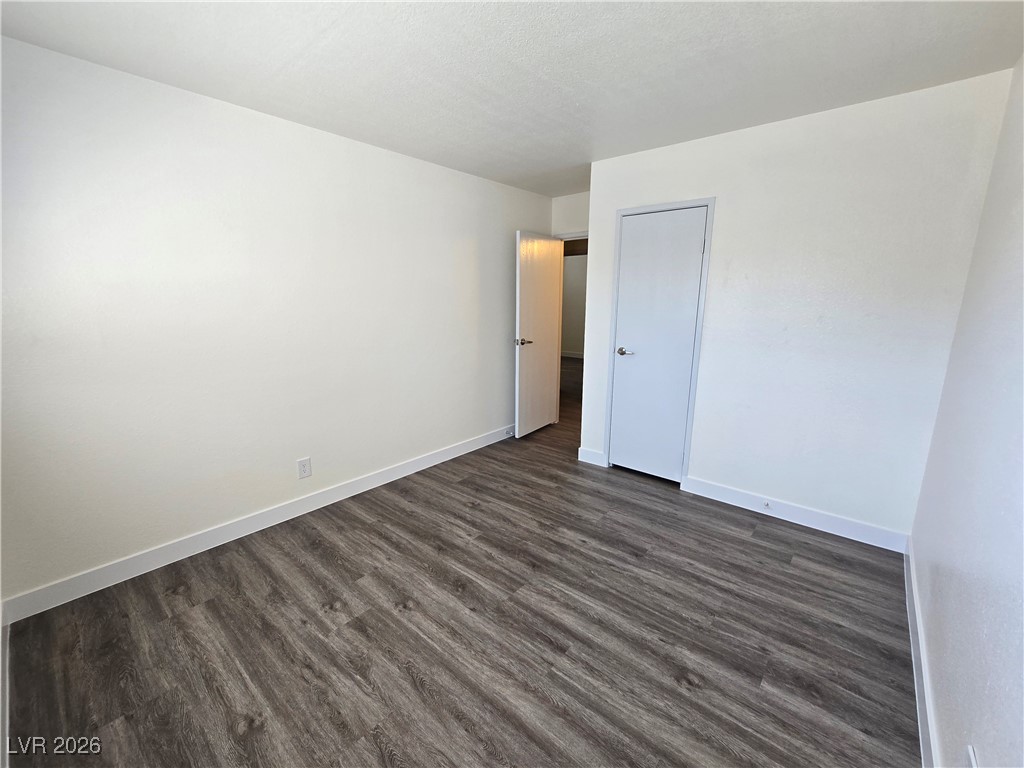 4219 Studio Street Las Vegas, NV 89115 - Photo 12 of 33 Unfurnished bedroom featuring dark wood-style floors