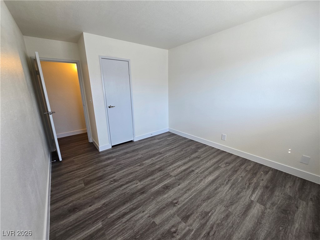 4219 Studio Street Las Vegas, NV 89115 - Photo 14 of 33 Unfurnished bedroom with dark wood finished floors and baseboards