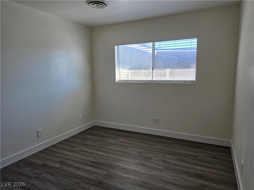 4219 Studio Street Las Vegas, NV 89115 - Photo 15 of 33 Spare room with dark wood-type flooring and baseboards