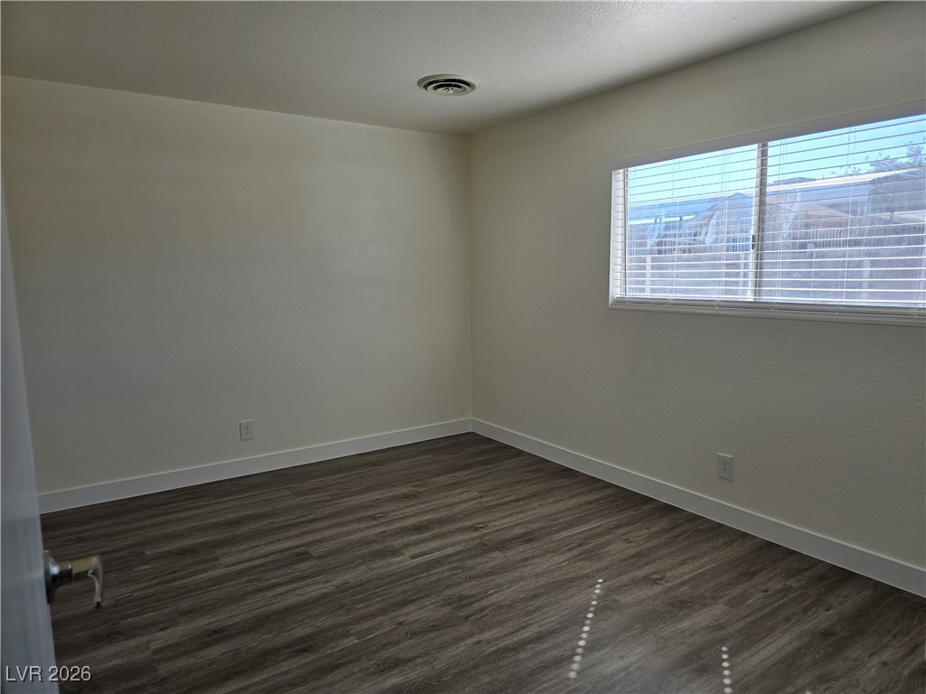 4219 Studio Street Las Vegas, NV 89115 - Photo 17 of 33 Empty room with dark wood-type flooring and a textured ceiling
