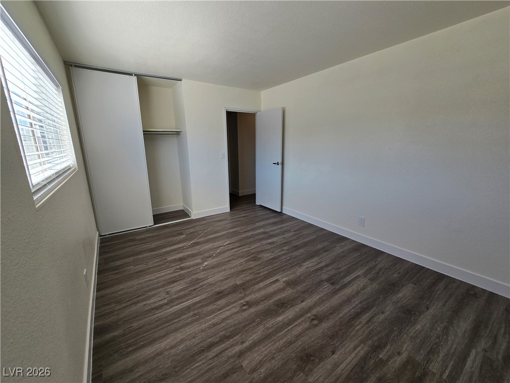 4219 Studio Street Las Vegas, NV 89115 - Photo 18 of 33 Unfurnished bedroom featuring dark wood finished floors and a closet