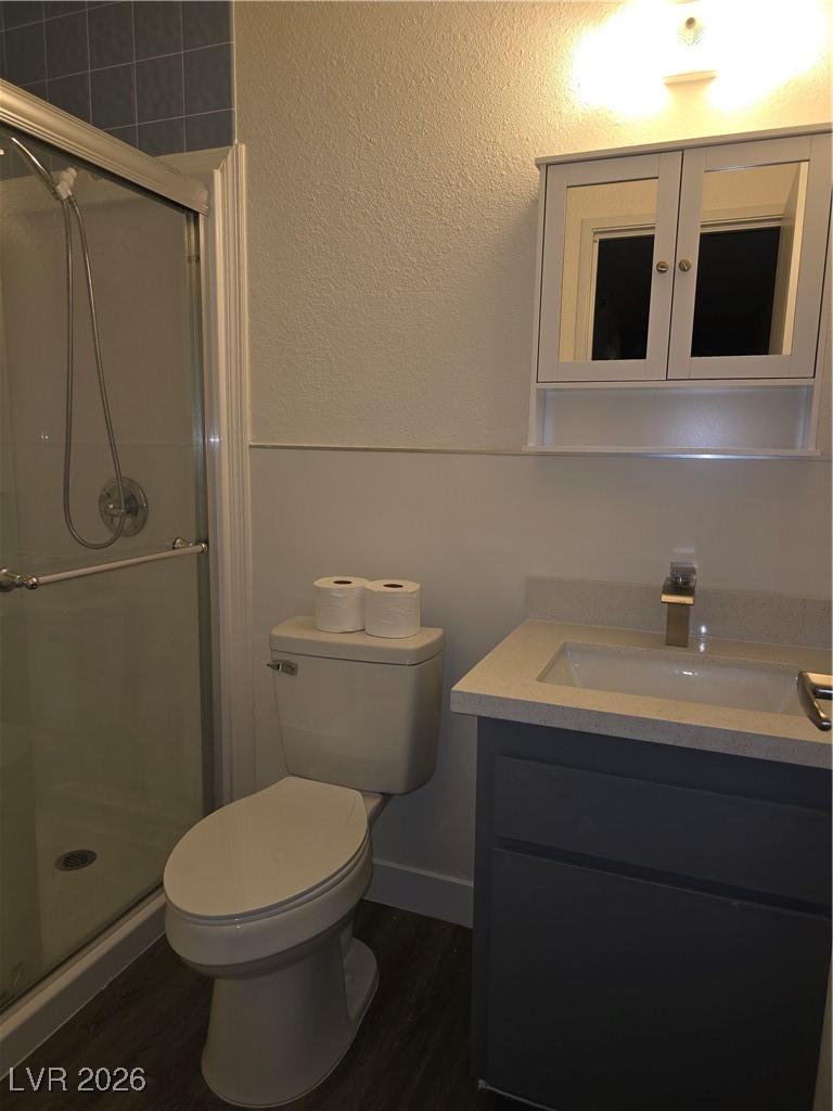 4219 Studio Street Las Vegas, NV 89115 - Photo 19 of 33 Full bath featuring a stall shower, vanity, dark wood-style flooring, and a textured wall