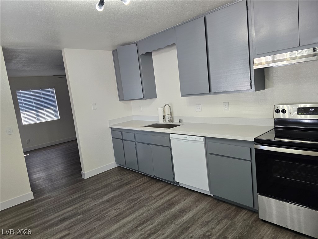 4219 Studio Street Las Vegas, NV 89115 - Photo 4 of 33 Kitchen featuring gray cabinets, electric stove, dark wood finished floors, white dishwasher, and light countertops