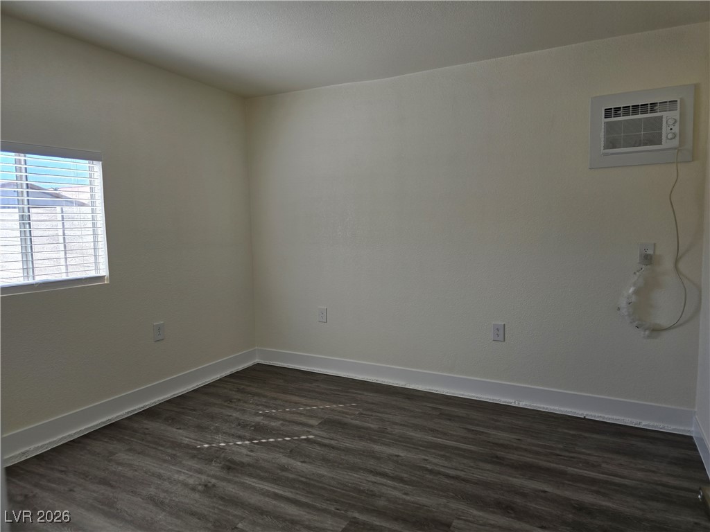 4219 Studio Street Las Vegas, NV 89115 - Photo 6 of 33 Spare room with dark wood-type flooring and a wall mounted AC