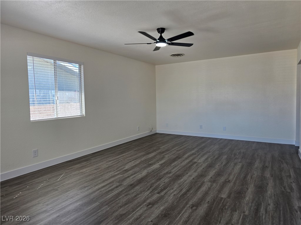 4219 Studio Street Las Vegas, NV 89115 - Photo 7 of 33 Spare room featuring dark wood-style floors, a ceiling fan, and a textured ceiling